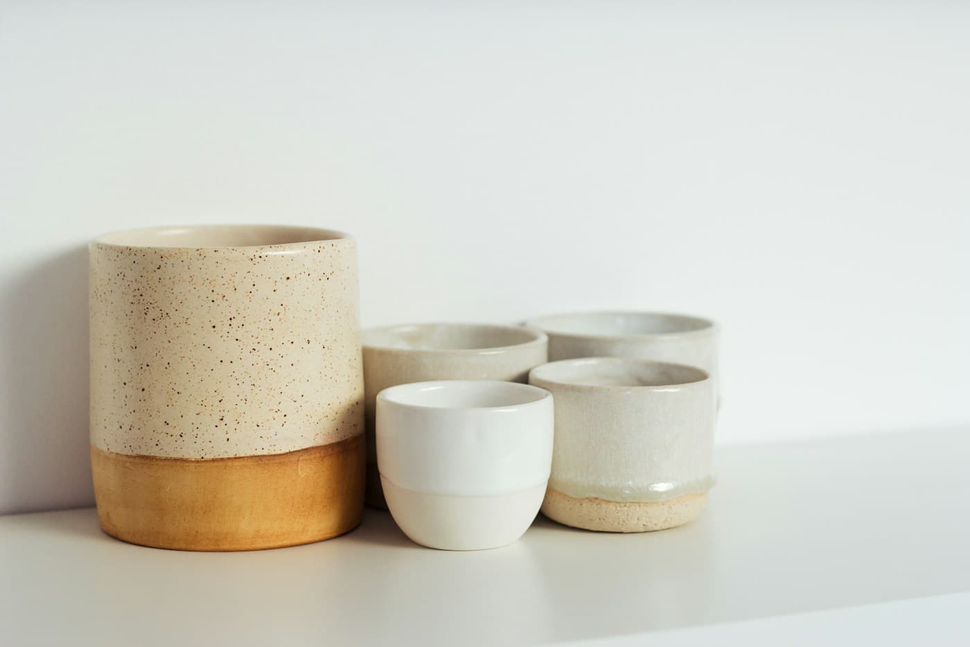Artisan ceramics and linen on warm stone in soft morning light